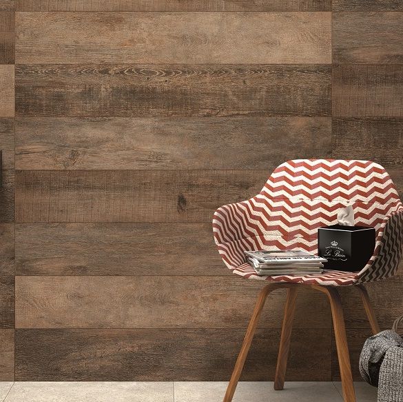 A long wood look flooring tile, the Dujour Natural Ember, used on a wall behind a chair. 