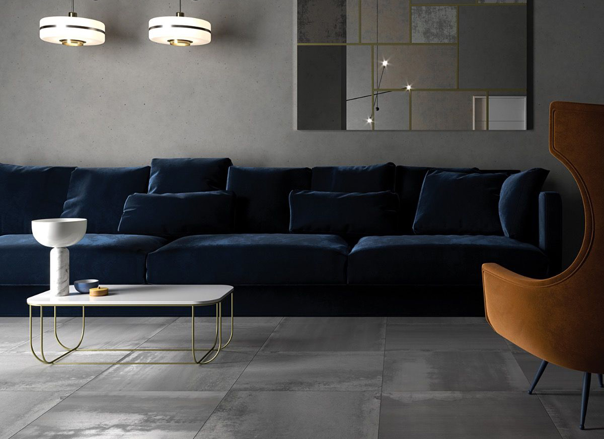 Large stone look tiles used on the floor with blue velvet sofa to show a nice contrast. Tiling to cater for the industrial design.